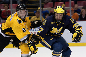 Michigan's Mac Bennett and Michigan Tech's Jacob Johnston fight for the puck. (Erica Treais)