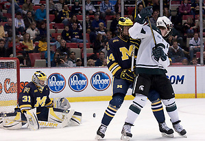 Michigan State assistant captain Trevor Nill and University of Michigan's Jon Merrill look for the puck in front of the Wolverine goal. The Spartan's came out with a 2-1 win; Joey Shean scored the game winning goal with less than seven minutes left in the game. (Erica Treais)